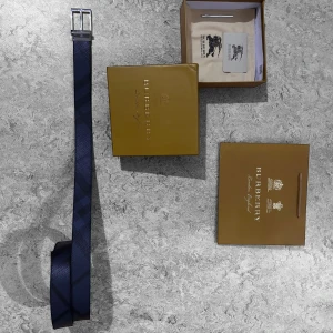 Burberry Bälte - Äkta läder. Allt medföljer. Även verktyg för att göra extra hål. 110 cm. Svart och marinblå.