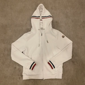 Moncler zip - Säljer den eftersom den är för liten för mig. Tröjan har inga skador eller fläckar, den är bara använd ett par gånger. Klassisk och clean look med snygga detaljer. Dm för fler bilder eller frågor!