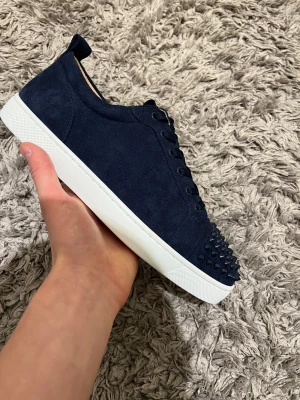 Christian Louboutins - Säljer ett par mörkblå sneakers från Christian Louboutin. Skorna har snörning och är tillverkade i mocka. För ett jätte bra pris, kom dm vid frågor😇