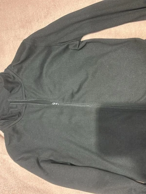 Svart hoodie med dragkedja - Svart träningskofta . Tröjan har en enkel och clean design utan synliga loggor eller mönster, perfekt för dig som gillar basic och stilrent. Materialet känns mjukt och bekvämt mot huden.