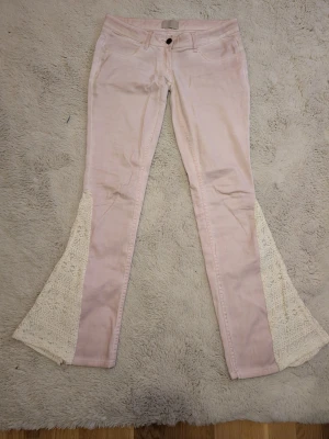 Superlågmidjade rosa jeans med spetsdetaljer - Ett par skitsnygga jeans som jag designat själv,  mått: midja: 38 inrebenslängd: 78 midjehöjden: 15