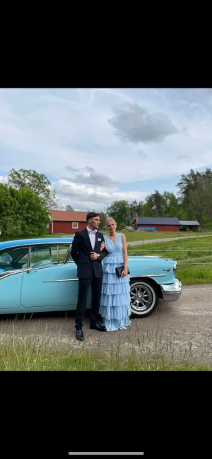 Ljusblå balklänning med volanger - Säljer en ljusblå långklänning från Bubbleroom med flera lager volanger och v-ringad omlott upptill. Klänningen är ärmlös och har en öppen rygg samt dragkedja i sidan. Materialet är lätt och skirt, perfekt för student eller bal. Supersnygg och drömmig look! Inga synliga skavanker förutom svagt missfärgad längst ner där den dragit i marken, använd under endast en kväll. Nypris: 1800💗