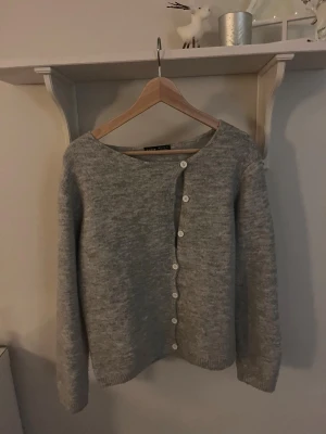 Grå kofta med knappar  - Mysig grå kofta, med rund hals och vita knappar framtill. Tröjan är stickad i mjukt material och har långa ärmar. Perfekt för dig som gillar enkel och stilren design. Den är från SHEIN men har inte konstig lukt och är vädligt mjuk mysig och varm. Tveka inte att skriva om fler bilder/frågor❤️❤️