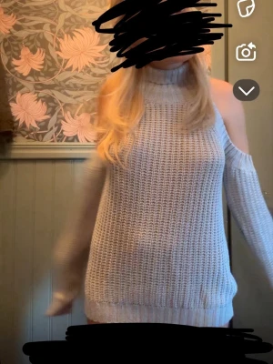 Ljusgrå stickad polotröja offshoulder - Säljer en ljusgrå stickad polotröja med offshoulder-design och lång ärm. Tröjan har en hög krage och ett grovt stickat mönster som ger en chill vibe. Perfekt för dig som gillar att sticka ut med coola detaljer.