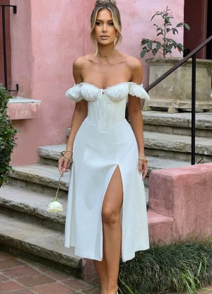 Vit offshoulder klänning Babyboo M - Säljer en supersöt och romantisk vit offshoulder klänning från Babyboo med puffärmar, med inbyggd korsett perfekt för att få en snatched look och har en slits framtill.  Köptes för 1200kr från Babyboo fashion. Använd bara en gång för bilder. Säljs då den är lite för stor för mig.