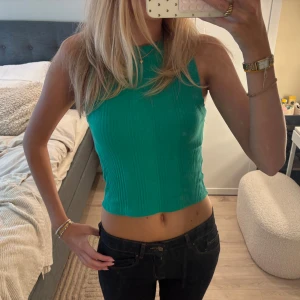 Grön ribbad croppad linnetopp - Fin grönt croppad linnetopp med ribbad struktur och hög hals. 