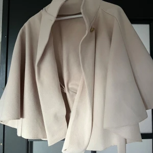 Beige kappa från Missay - Säljer en snygg beige kappa från Missay med elegant, svepande form och en enkel knapp framtill. Jackan har en klassisk krage och är tillverkad i ett mjukt material som ger en lyxig känsla🪷