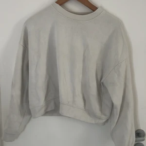 Vit sweatshirt från 157 i XS/S - En basic vit sweatshirt från 157 i storlek XS/S. Tröjan har en klassisk rund halsringning, ribbade muddar och är tillverkad i mjuk bomullsblandning. Perfekt för en avslappnad och stilren look.