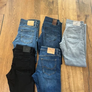 Jack & Jones jeans i olika färger - Fem par jeans från Jack & Jones i olika färger: svart, ljusblå, mellanblå, mörkblå och ljusgrå.  Säljer för 70 kr styck, Klassisk femficksmodell med raka ben och normal passform. Jeansen är tillverkade i bomull med en liten del stretch för extra komfort. Modellen på alla är slim/glenn alla är i storlek 30/32 förutom dom svarta som är i 31/32