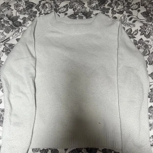 Vit stickad tröja från Vero Moda - Enkel och stilren ljus stickad tröja från Vero Moda. Tröjan har rund halsringning, ribbade muddar och är långärmad. Perfekt för lager-på-lager och passar till allt. Snygg och basic modell som är lätt att matcha.