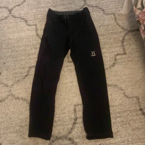 Svarta friluftsbyxor från Haglöfs - Svarta friluftsbyxor från Haglöfs med dragkedjefickor och logga på låret. (Sänker pris vid snabbaffär)