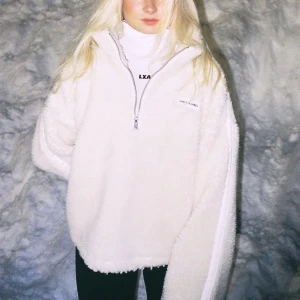 Vit fleece half zip från LXA The Label - Supermjuk och oversized vit fleece-tröja från LXA The Label med half zip och hög krage. Perfekt för kalla dagar, med broderad logga på bröstet och långärmad passform. Snygg och cozy vibe, passar till allt. Finns inte att köpa på hemsidan längre❤️