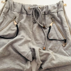 Sweatpants mysbyxor - Eleganta, lite posh sportiga sköna mysbyxor som har multi använding till vardags men äcen på stan då de har fina detaljer i guldfärg. Detaljer såsom dragkedjor på vardera sida, guld detaljer på fickor. Nypris 599kr