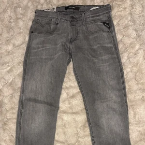 Replay Anbass grå jeans, stl 29 - Snygga grå Replay Anbass jeans i klassisk femficksmodell. Jeansen har raka ben, skinny passform. Tillverkade i mjukt. Perfekta för dig som gillar stilrena och moderna jeans.