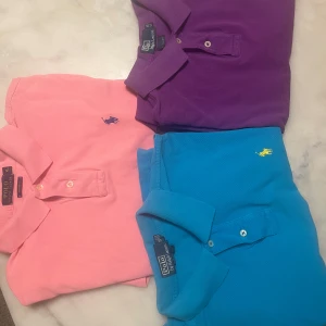 Pikétröjor från Polo Ralph Lauren XL - Tre snygga pikétröjor från Polo Ralph Lauren i färgerna rosa, blå och lila. Klassisk pikékrage, kort ärm och broderad logga på bröstet. Perfekt passform med custom fit och coola färgkombos. Materialet är bomull som andas och känns skönt mot huden.