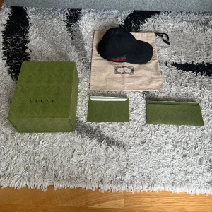 Svart keps från Gucci  - Säljer nu min Gucci keps i nyskick, kepsen är äkta och kvitto finns. Alla tillbehör på bilden följer med. Vid fler bilder eller frågor är det bara att skriva. Säljer endast.