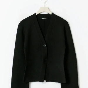 Svart kofta från Gina Tricot - Svart kofta från Gina Tricot med v-ringning och två knappar framtill. Långärmad och i en mjuk, stickad kvalitet som sitter snyggt. Slt S men skulle enkelt passa en som har stl M. Aldrig använd men har tagit bort lappen.               Original pris 460. Pris kan diskuteras:)