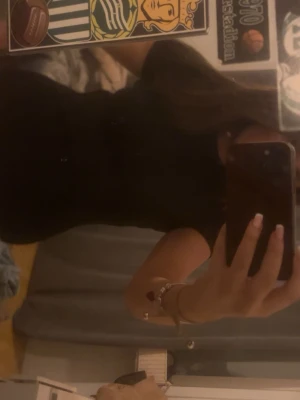 Svart ribbad topp med kort ärm - En svart ribbad topp med korta ärmar och rund hals. Sitter tight och har en enkel, stilren look som passar till det mesta. Perfekt basplagg för alla tillfällen.