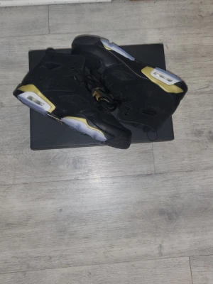Nike Air Jordan 6 svart/guld sneakers - Helt nya skor, aldrig använda. Originalkartong ingår. Inga defekter. 