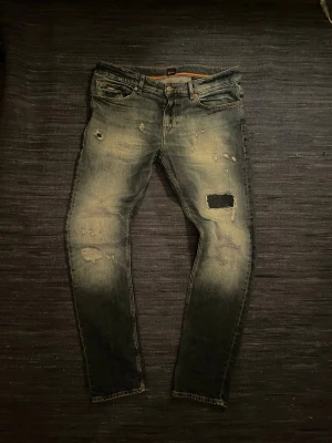 Hugo boss jeans  - Tja! Säljer nu ett par riktigt feta Hugo boss slim jeans i Delaware modellen med otroligt feta slitningar. Skicket på dessa är allmänt ganska bra men det är ett litet hål på en av bakfickorna. Kom gärna med frågor eller bud!