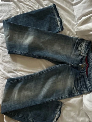 Blå jeans från Cross - Säljer ett par blå jeans från Cross med slitna detaljer. Jeansen har klassisk design, ljus tvätt och är lågmidjade. Lite för små så skriv privat för bilder på!  