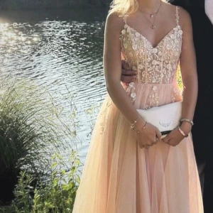 Ljusrosa balklänning  med blommor - Intresse koll! Säljer nu min balklänning som används 1 gång! Nypris 5000kr! Skriv om ni vill ha fler bilder!