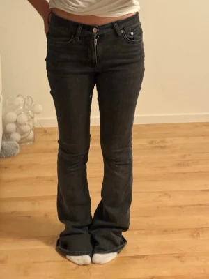 Mörkgrå bootcut jeans från Gina Tricot - Snygga mörkgrå bootcut jeans från Gina Tricot med klassisk femficksmodell och normalhög midja. Jeansen har en lätt utsvängd passform nedtill och är gjorda i mjukt denimtyg med lite stretch för extra komfort.