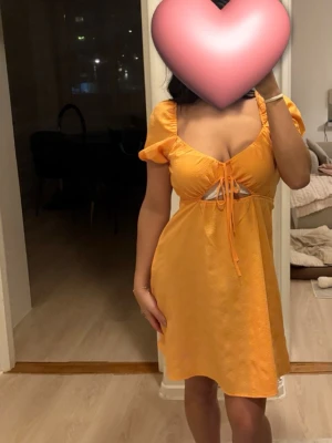 Gul kort puffärmad klänning H&M - Söt gul kort klänning från H&M med puffärmar och knyt framtill. Klänningen har en omlottliknande urringning och är tillverkad i ett lätt, strukturerat tyg som passar perfekt för varma dagar. Supersnygg och trendig modell! Jättesöt😍Klänningen är storlek M och jag har storlek xs/s egentligen. För lite referens🫶🏽