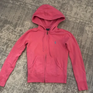 Rosa Polo Ralph Lauren hoodie  - Säljer min jättefina Rosa Polo Ralph Lauren Hoodie med turkos häst. Väldigt fin och unik färg och perfekt till flera olika tillfällen. 