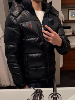 Ralph lauren dunjacka - Ralph lauren jacka i väldigt bra skick, storlek S i färg svart,glossy köpt från boozt kvitto går att hitta och alla tags finns kvar+ påsen jackan kom i.