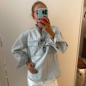 Ljusblå denim henley-skjorta - Ljusblå skjorta i denim med avslappnad passform.  Perfekt för en chill och trendig look.