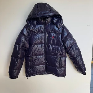 Ralph lauren jacka -  Ralph lauren jacka i storlek Small, jackan passar ca från 65-85 kg  Och sitter nånstans mellan small och medium. Den har inga hål eller skador köp för 6995 kr ifrån Nk syns på kvittot i bilden. jag sickar med jackan lapparna och kvittot vid köp! Skriv om ni har frågor. jackan har legat undanlagd i en låda under vinter så den va skrynklig men den är ej det längre