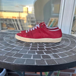 Saint Laurent skor - Snygga röda sneakers från Saint Laurent  i bra skick, storlek 41,5. Man får med skor och dustbag. Hade kunnat byta om någon har samma par i 42-42,5. Pris kan diskuteras vid snabb affär, skriv om ni undrar över något!