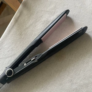 BaByliss Paris Slim Plattång - BaByliss Paris Slim plattång i svart med keramiska plattor. Justerbar temperatur och lång sladd för enkel användning. Produkten är i mycket gott skick utan synligt slitage eller defekter. Perfekt för att skapa släta och glansiga frisyrer hemma.