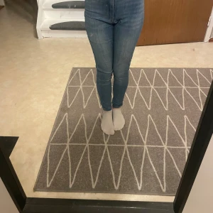 Blå Molly jeans från Gina Tricot S - Säljer ett par blå Molly jeans från Gina Tricot i storlek S. De är högmidjade med skinny passform och klassisk femficksdesign. Jeansen är i stretchigt denim och har dragkedja och knapp framtill. Perfekta för dig som gillar en tight och bekväm look.