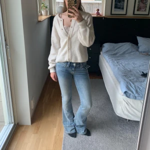 Ljusblåa True Religion JOEY Low Rise Flare  - Säljer ett par ljusblå jeans från True Religion med bootcut passform och lågmidjad passform, jeansen har snygga detaljerade bakfickor med knappar. Jag köpte jeansen i somras men de är knappt använda (inga märken eller avtryck), jag säljer dem på grund av att de inte passar mig. Skriv om du har några frågor eller vill ha fler bilder💓