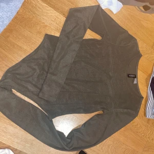 Mörkgrön långärmad topp från Iconic - Snygg mörkgrön långärmad topp från Iconic med rund halsringning. Tunn och mjuk i materialet, perfekt att styla med jeans eller kjol. Enkel design utan mönster eller detaljer, passar dig som gillar stilrena plagg.