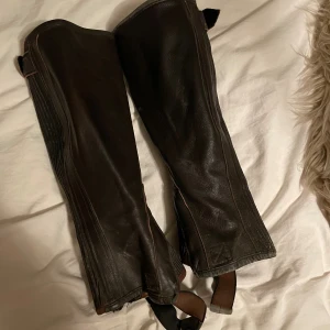 Bruna läder chaps - Säljer dessa bruna läder chaps då jag inte använder de längre. Snygga och sitter jätte bekvämt på benen.