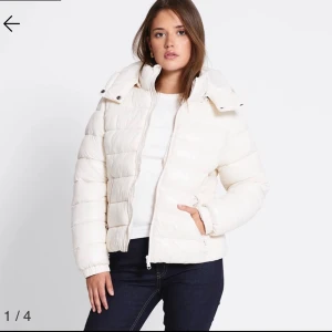 Vit pufferjacka med huva - Säljer en fräsch vit pufferjacka med huva och dragkedja framtill. Jackan har quiltad design och är lite kortare i modellen, vilket ger en snygg och modern look. Perfekt för dig som vill ha en varm och stilren jacka till vintern. Helt ny med prislapp 