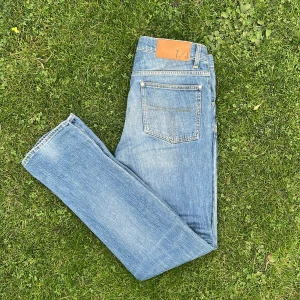 Jeans Tiger of Sweden - Säljer ett par ljusblå jeans från Tiger of Sweden. Jeansen är använda och har ett litet hål vid gylfen. Passformen är lite lösare slim fit. Storlek 30/32. Passar mig perfekt som är 184cm och 75kg