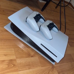 PlayStation 5 med två DualSense-kontroller - Säljer en PlayStation 5 i mycket fint skick, komplett med två DualSense trådlösa kontroller. Konsolen och kontrollerna ser ut att vara välvårdade utan synliga repor eller skador. Perfekt för gaming med vänner eller familj. Ps är använt Sällan mest stått. Hämtas fraktar inte. 