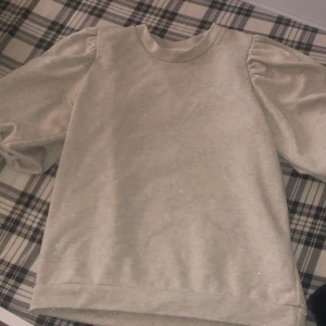 ✨Beige puffärmad tröja✨ - Supersöt tröja i beige med lätt puffarm och diskret glitter i tyget. Mjuk och bekväm, perfekt att klä upp eller ner beroende på tillfälle. Använd ett par gånger och det finns inga skador. För att se den på skriv privat och priset kan diskuteras!