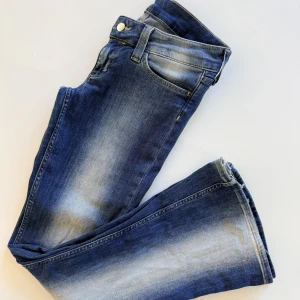 Cheap Monday Bootcut Jeans Blå 29x32 - Snygga blå bootcut jeans med väldigt låg midja från Cheap Monday i stl 29/32, slitna nedtill pga för långa. Jeansen har en tvätt med ljusare partier och är tillverkade i en mix av bomull, polyester och elastan för skön stretch.