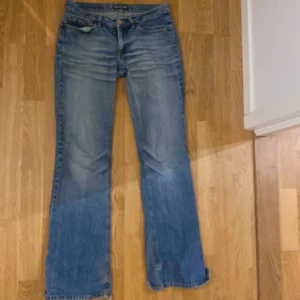 Levis 517 blå bootcut jeans - Säljer ett par klassiska Levis 517 jeans i blå denim med bootcut passform. Jeansen har fem fickor, normal midja och slitna benslut för en cool, avslappnad vibe. Perfekta för dig som gillar retrostil och vill ha ett par jeans med lite edge. Ganska mycket slitit på baksidan som ni ser där nere men annrs skit snygga måste dock själva för att dem e för små 