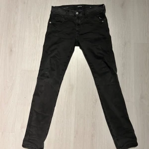 Replay jeans - Svarta jeans från Replay med modellen anbass (slim passform) och klassisk femficksdesign. Snygga detaljer med Replay-logga på fickan och bak på linningen. Jeansen har dragkedja och knapp framtill och är tillverkade i stretchigt jeansmaterial för en bekväm känsla. Storlek w28 l30 hör gärna av er med prisförslag eller om ni vill ha fler bilder eller mått!