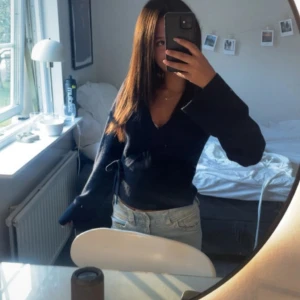 Mörkblå omlottkofta med v-ringning - Säljer en mörkblå omlottkofta med v-ringning och långa ärmar. Tröjan har knyt i sidan och är i storlek 152 passar xxs xs 