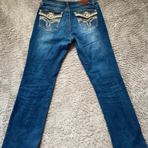 Stars & Stripes bootcut jeans - Snygga blå bootcut jeans från Stars & Stripes med unika bakfickor och låg midja. Innerbenslängd 75cm. Har varit uppsydda och sömmen längst ner är lite sne men inget man tänker på!💕