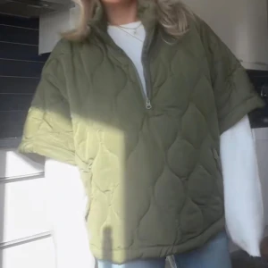 Olivgrön quiltad trekvartsärmad jacka half zip - Quiltad trekvartsärmadjacka i olivgrönt med halv dragkedja framtilll. Lite oversized passform och coolt mönster i tyget. Perfekt för lager-på-lager under höst och vinter. OBS! Jag har sytt upp jackan nertill då den var lite för lång (de två sista bilderna är på stygnen) men absolut ingenting man tänker på!☺️ Jag har enbart använt jackan 1 gång❤️