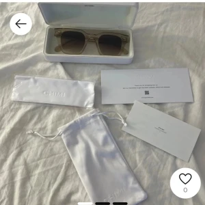 Beige solglasögon från Chimi04 eruc  - Snygga solglasögon från Chimi i en stilren beige färg. De har en fyrkantig form och kommer med ett praktiskt fodral och putsduk. Perfekta för att ge din outfit en trendig touch. 04 eruc. Skriv om egna bilder, allt med följer