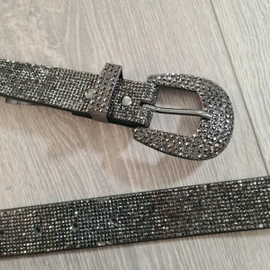 Glittrigt rhinestone bälte från Primark - Svartsilvrigt rhinestone bälte, från spännet till slut är det 120 cm. Några stenar lite slitna men inget som märks. Kolla in mina andra saker jag säljer!
